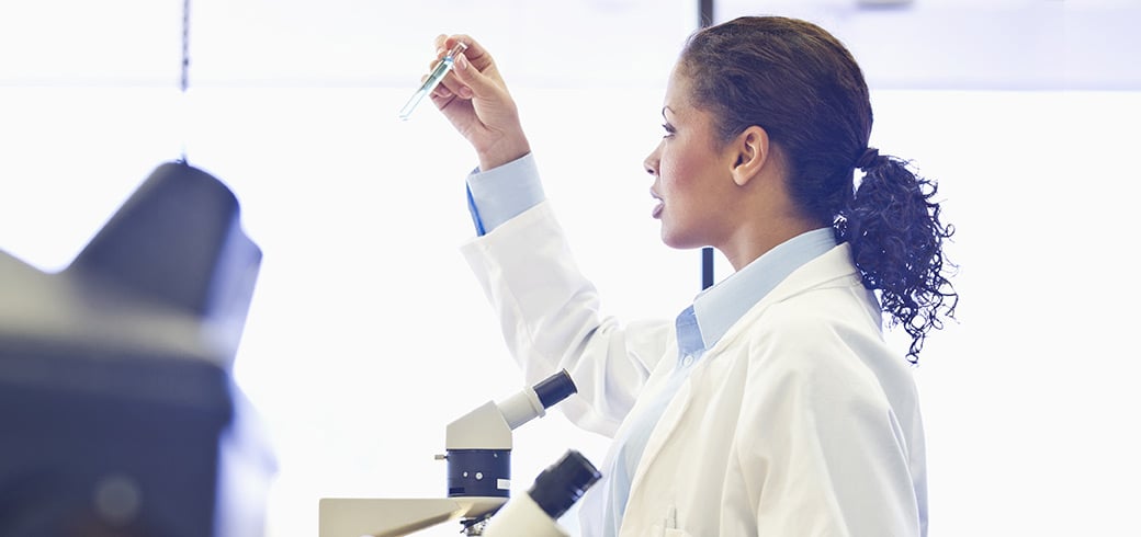 A doctor in a lab coat inspecting a test tube